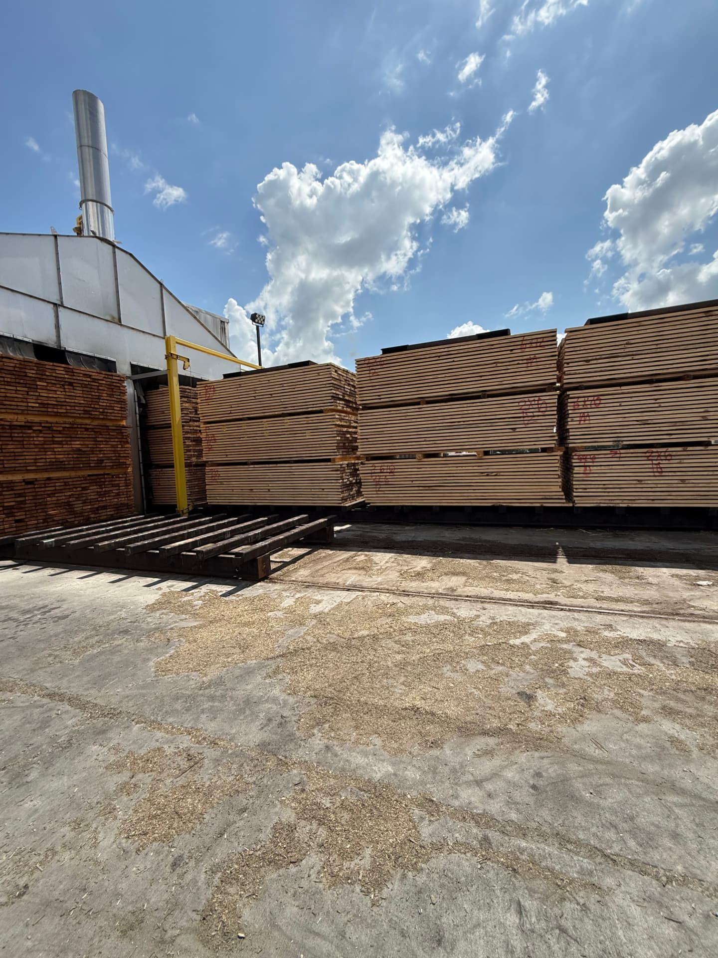 Kiln loading deck with stickered lumber packages staged for the next charge