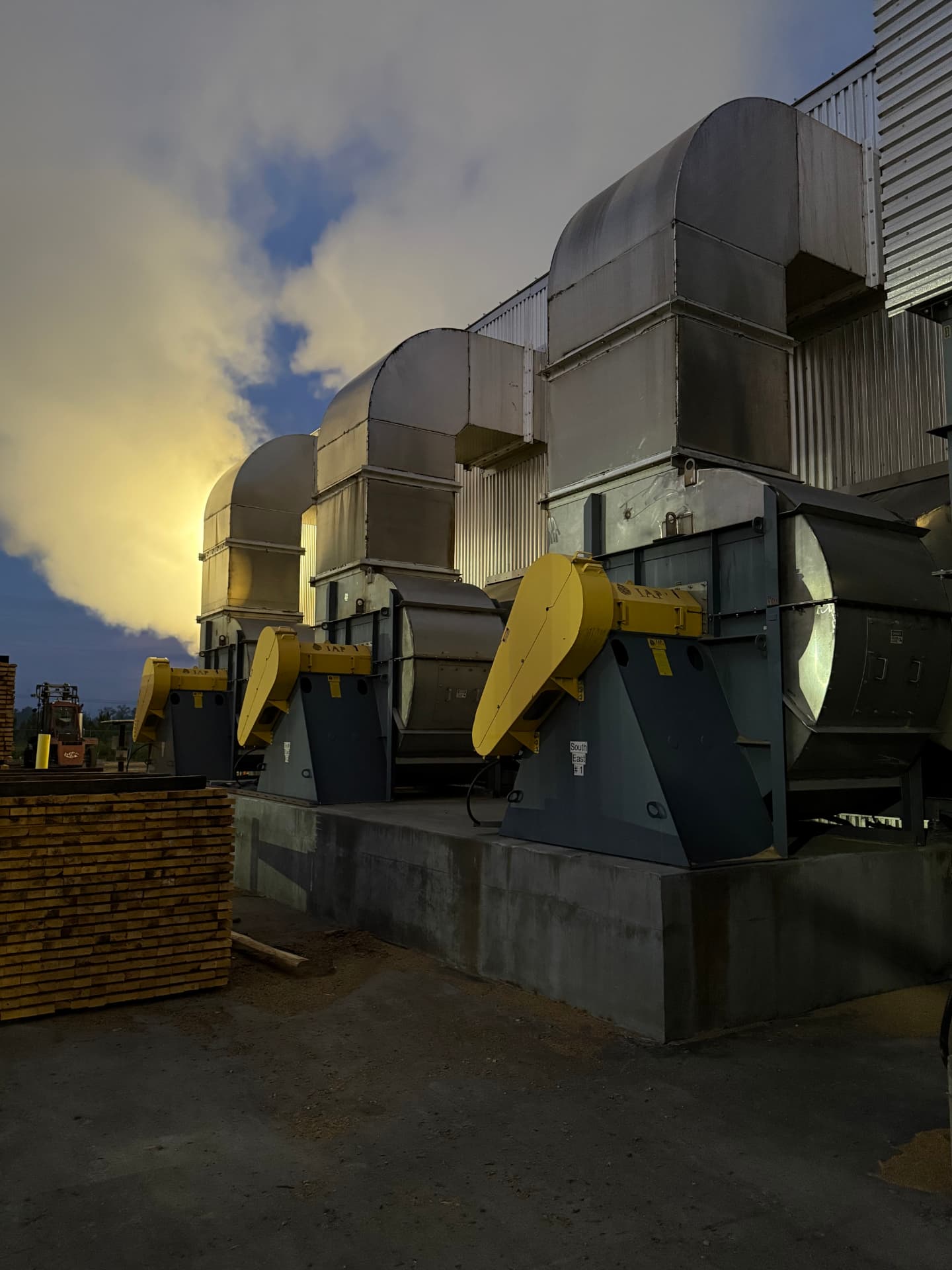 Kiln blower fans and ductwork running at dawn at a lumber drying facility