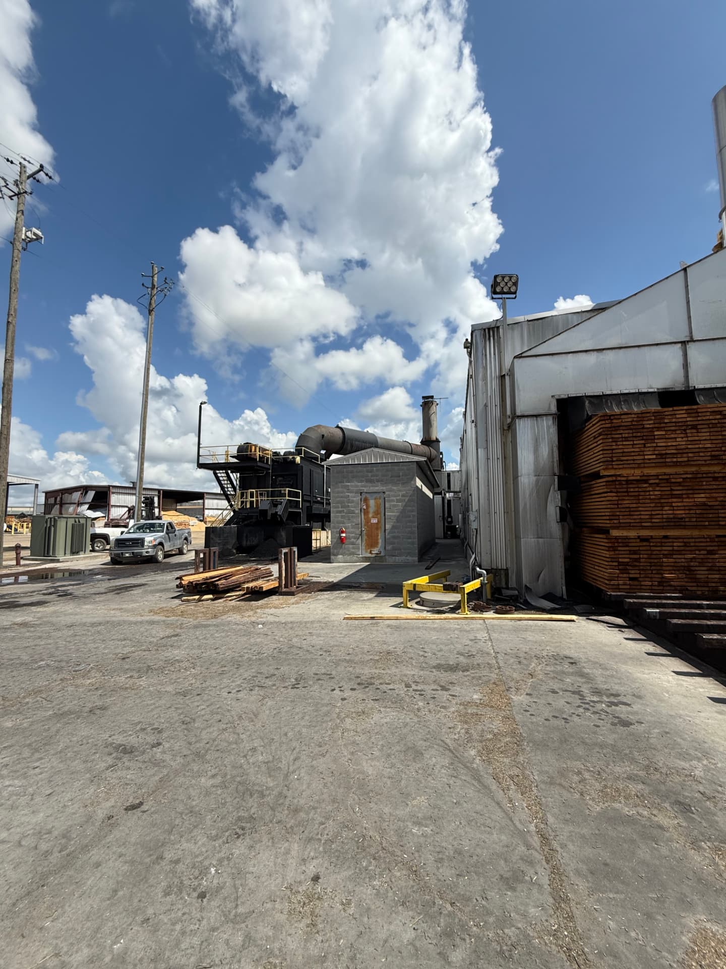 Sawmill yard with biomass burner and a lumber charge in the kiln door