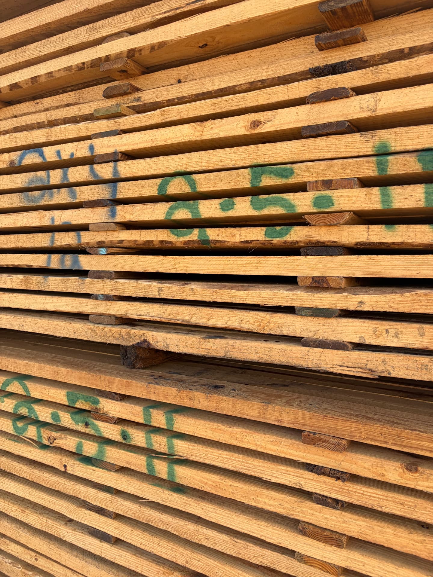 Close-up of stickered lumber stack with grade marks before kiln drying