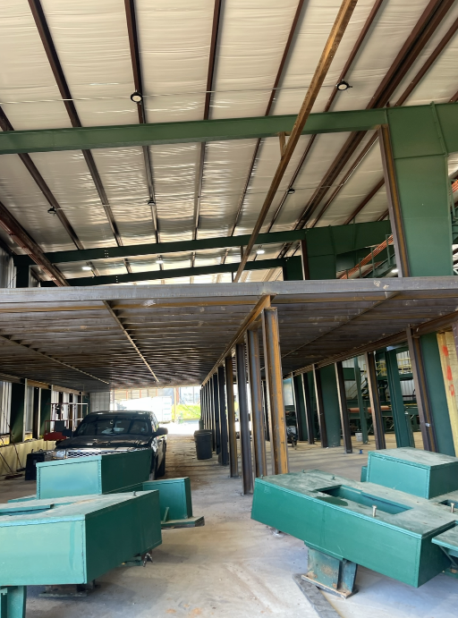 Sawmill mezzanine platform and material handling support structure inside an industrial facility